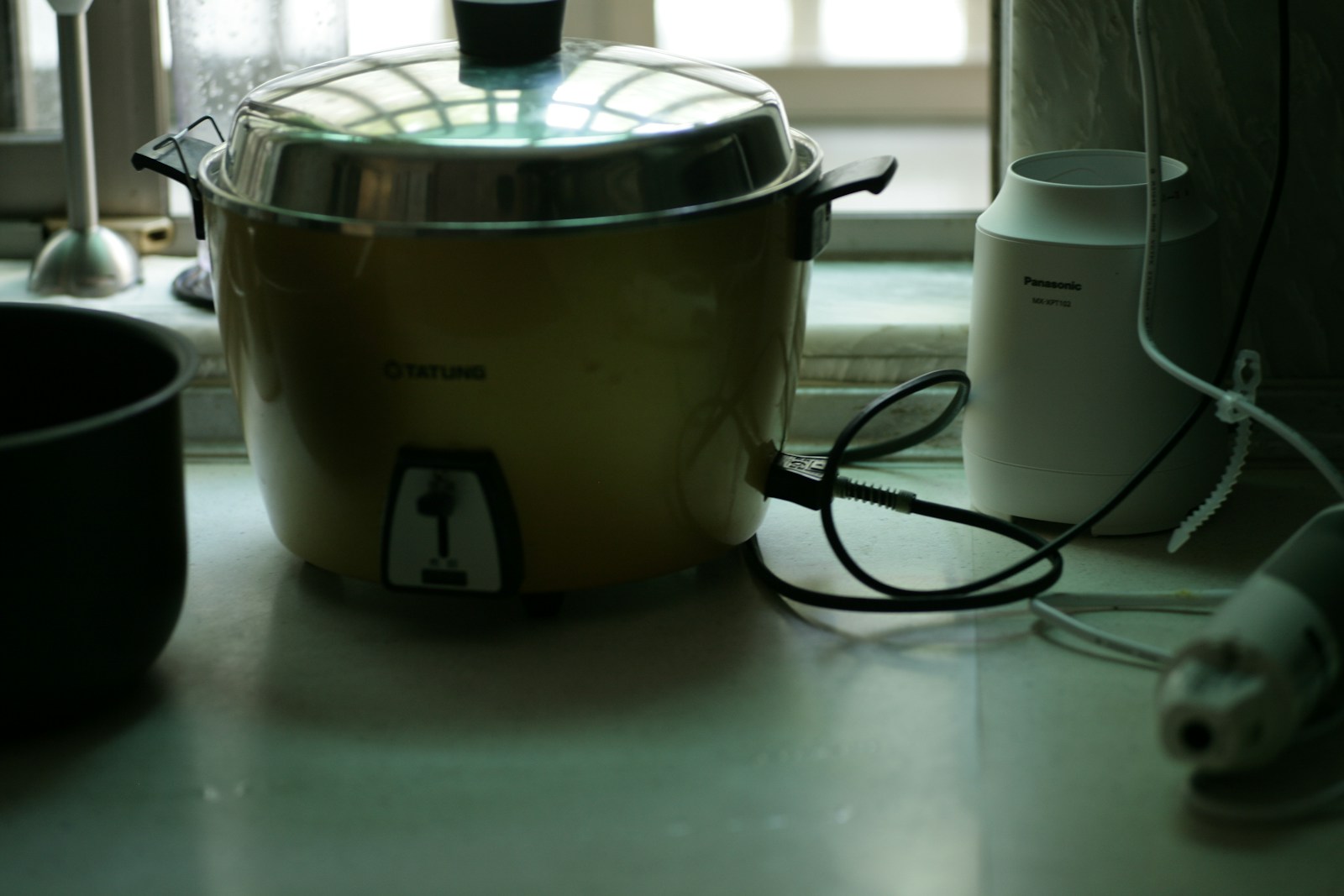 Rice cooker putih dan hitam di atas meja dapur